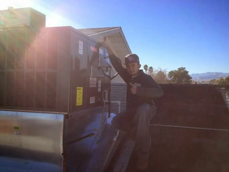 HVAC technician performing AC Tune-Up on a rooftop unit in Starkville